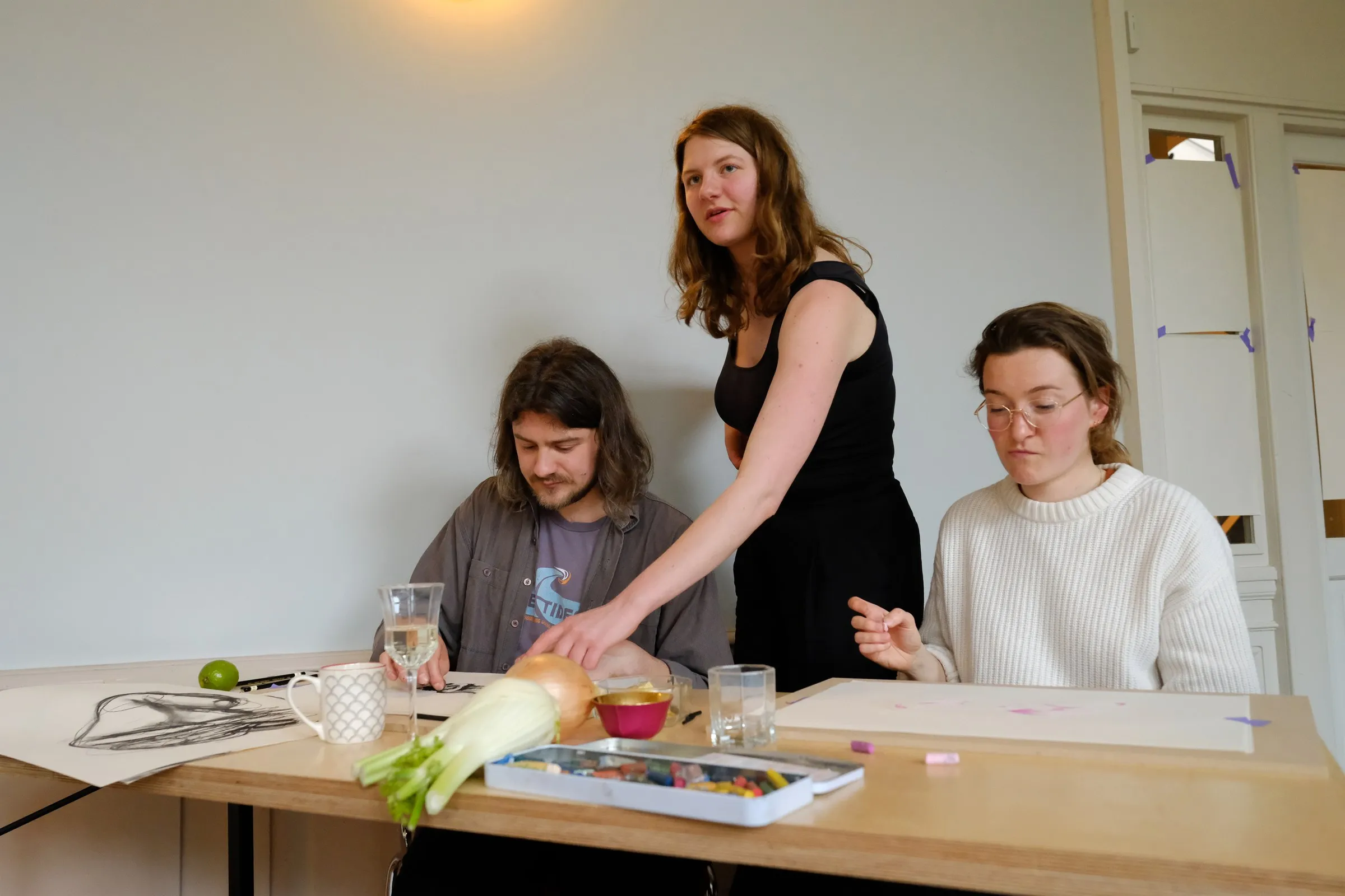 An artist guiding participants at the table