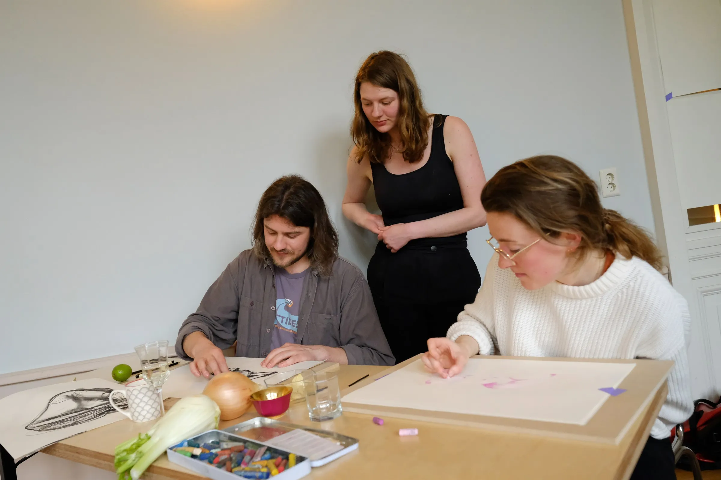One of the artists helping two participants