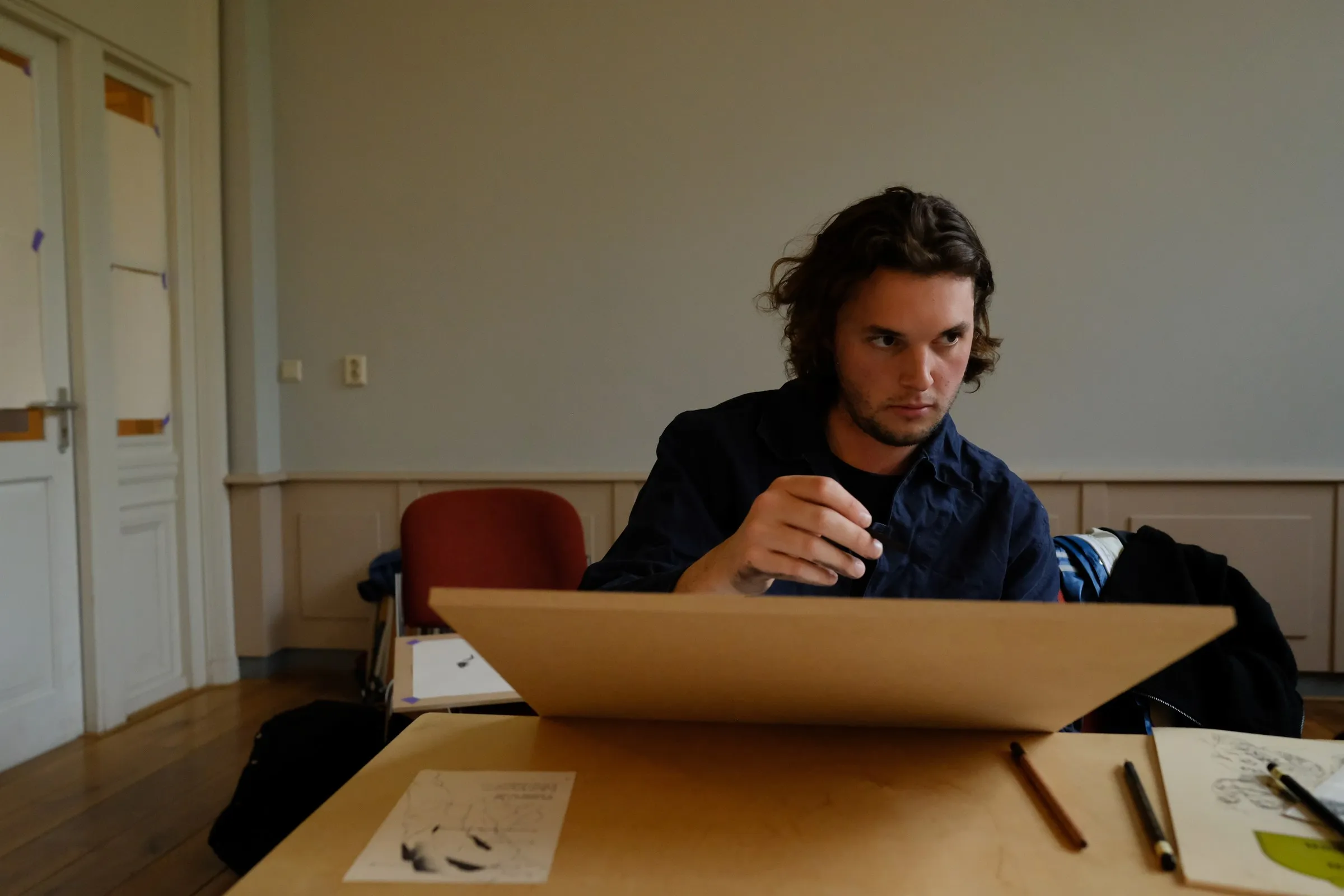 A participant concentrating over a drawing board