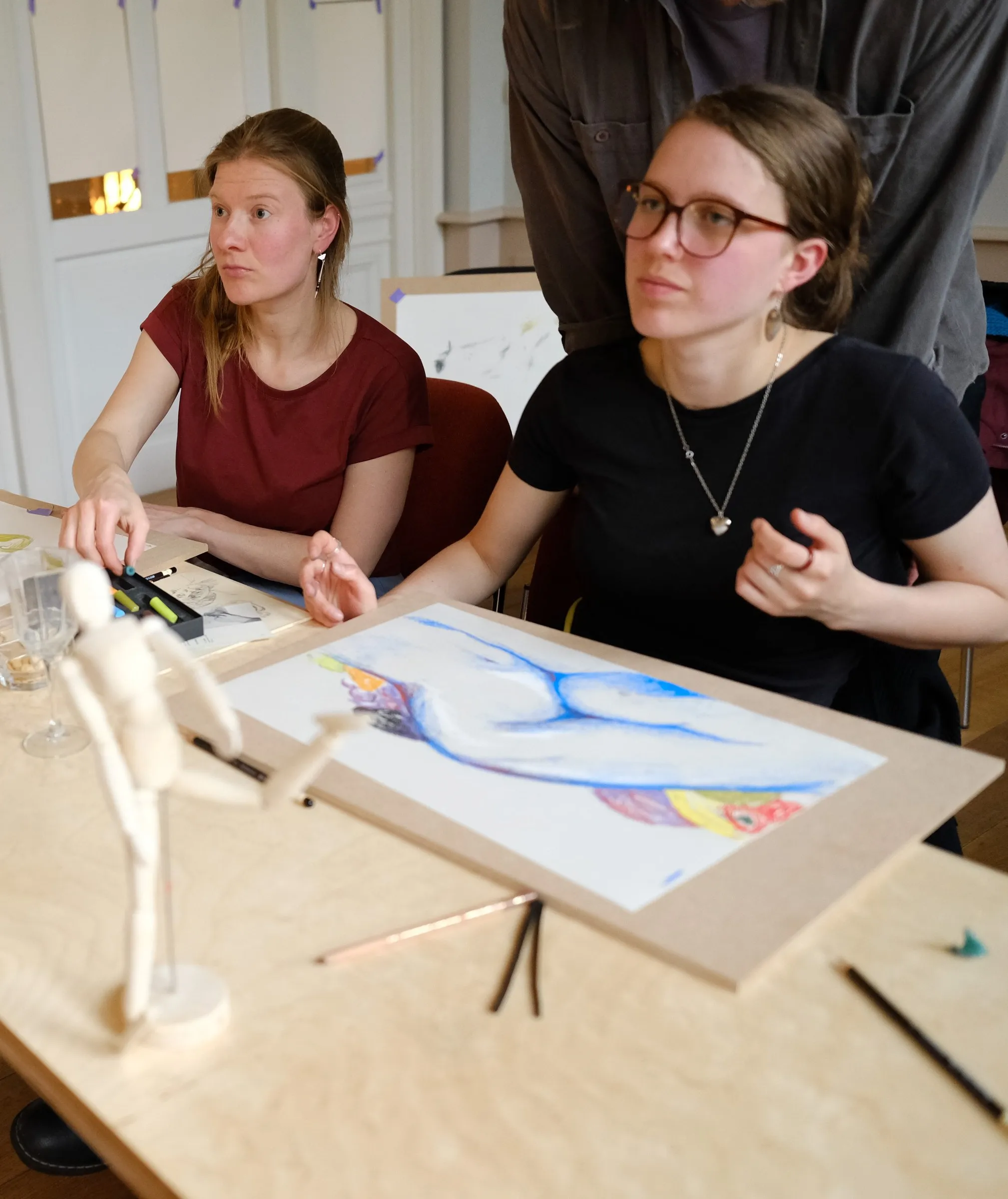 Two participants drawing together at the table